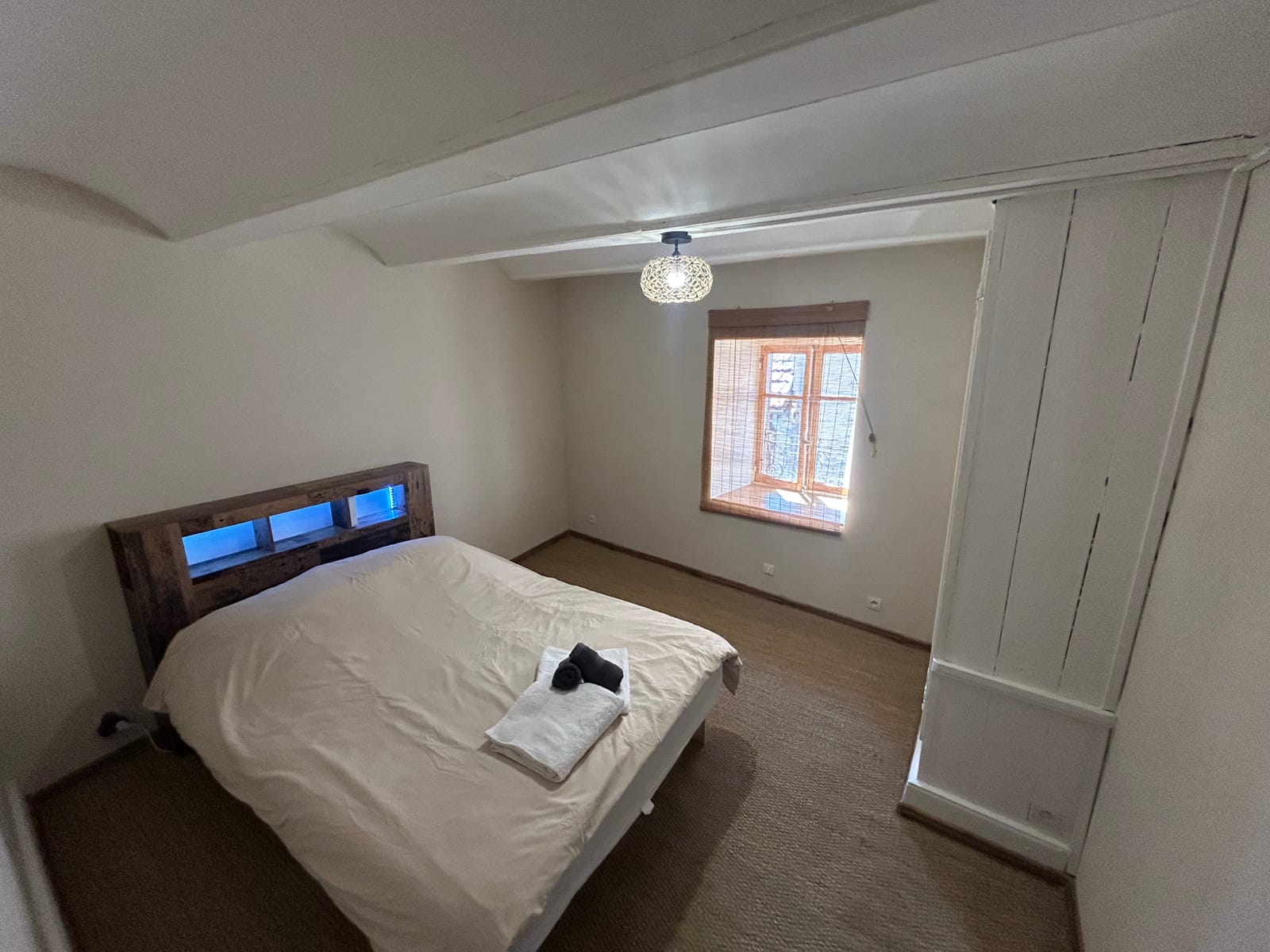 Chambre 1 du gîte à Cayres avec lit double et tête de lit lumineuse