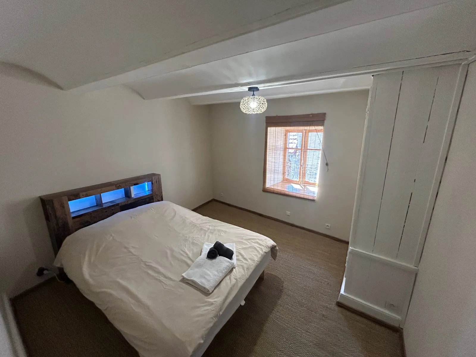 Chambre 1 du gîte à Cayres avec lit double et tête de lit lumineuse