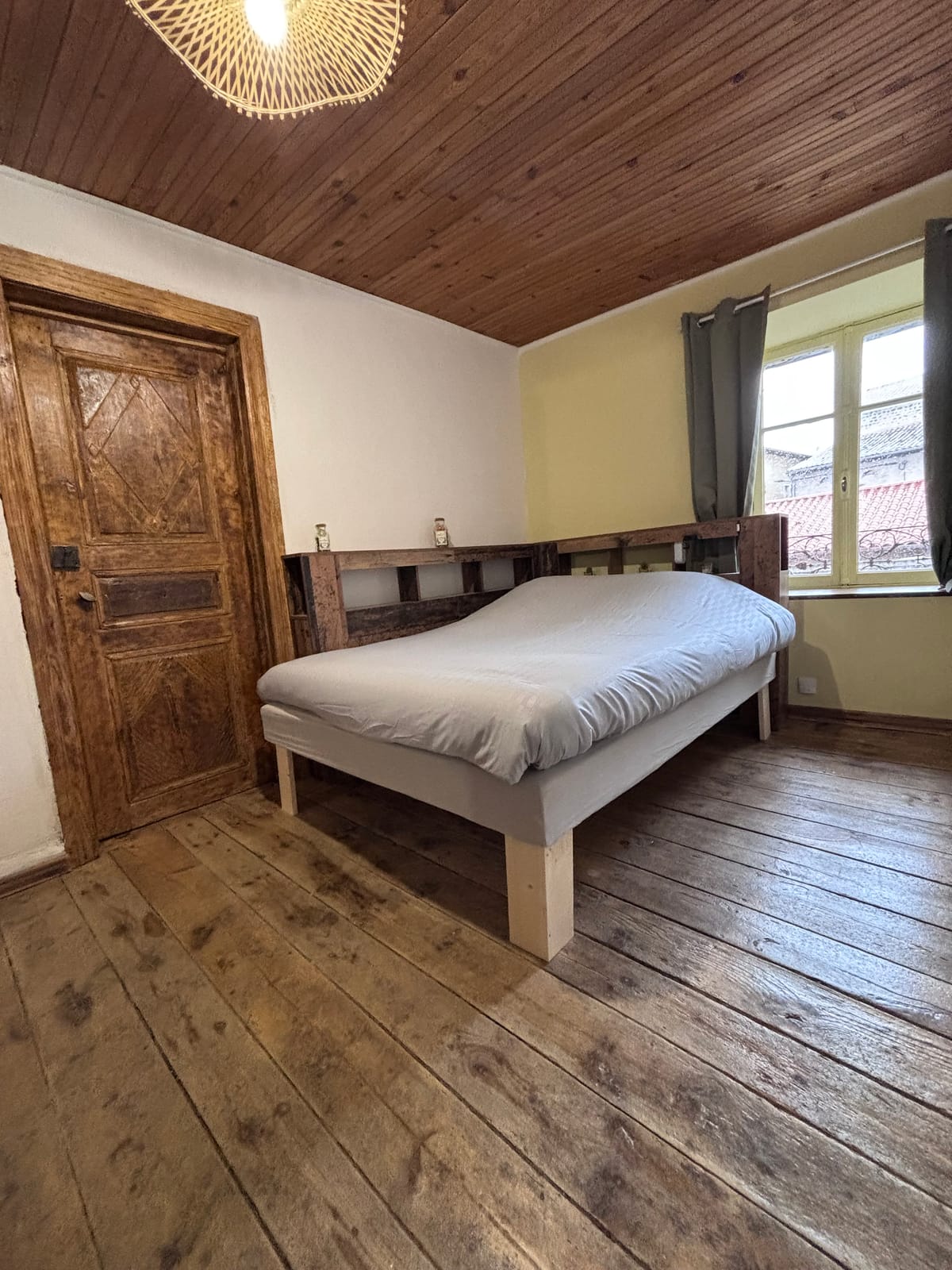 Chambre 2 du gîte à Cayres avec lit double, porte ancienne et fenêtre
