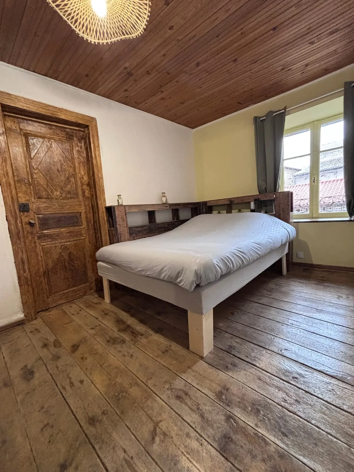 Chambre 2 du gîte à Cayres avec lit double, porte ancienne et fenêtre