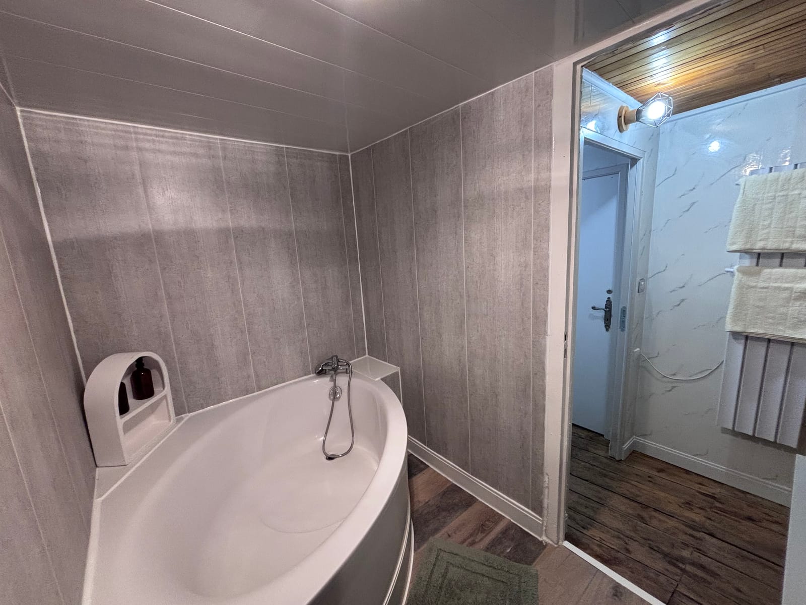 Salle de bain partagée du gîte à Cayres avec baignoire d'angle